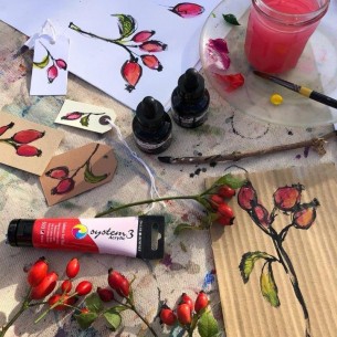 Paintings of plants on various mediums created using System 3 Acrylic paint, with a tube of Cadmium Red Hue on the table