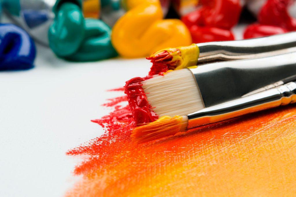 Paint brushes with red and yellow acrylic paint