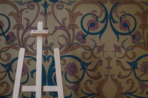 Wooden easel in front of coloured, patterned design