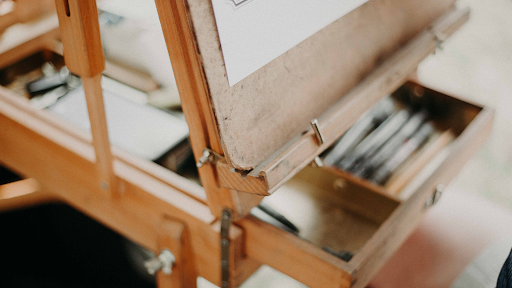 Wooden easel with a drawer containing art materials 