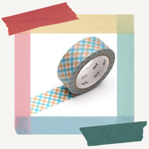 Roll of decorative paper masking tape from MT with an overlapping checkered design with blue and orange tones throughout