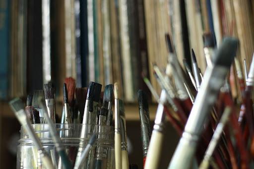 Paint brushes standing upright in glass jars