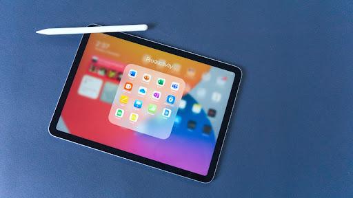 Apple iPad air on a blue background with an Apple Pencil