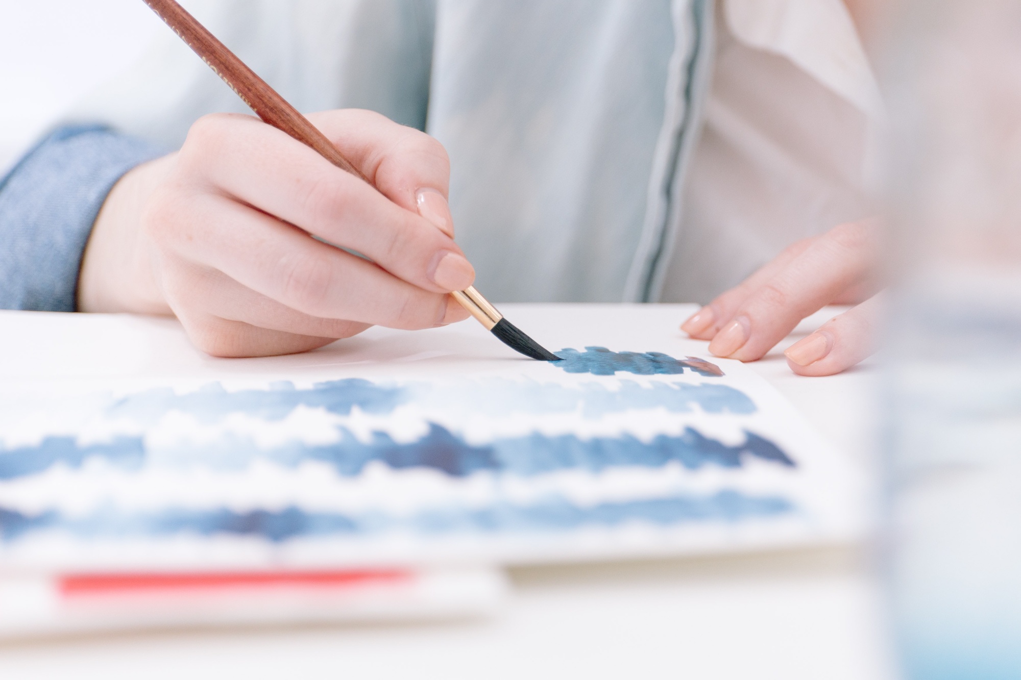 Person painting on paper with Gouache 